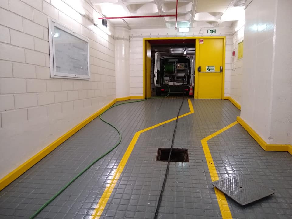 Garagem subterrânea de condomínio em Lisboa com carrinha DesentopeTOP a fazer desentupimento da rede pluvial pelo ralo central